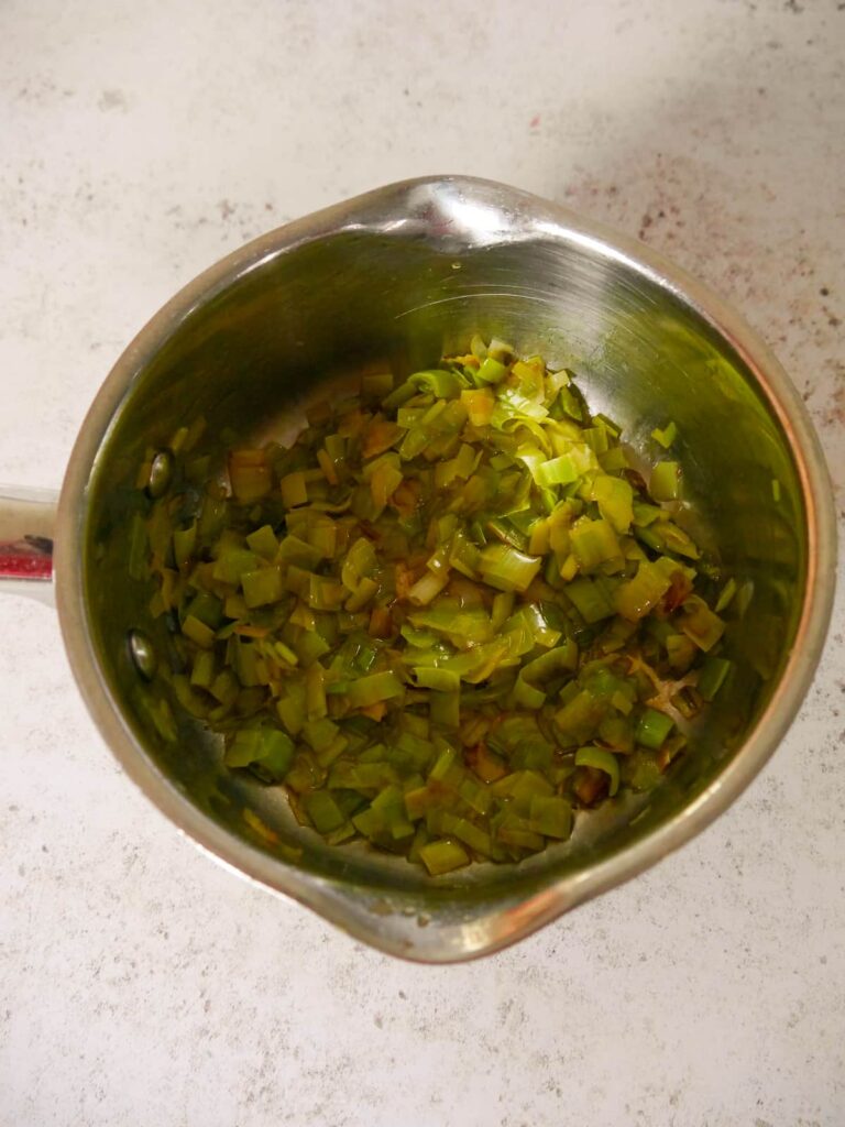 A saucepan filled with sauteed leeks.