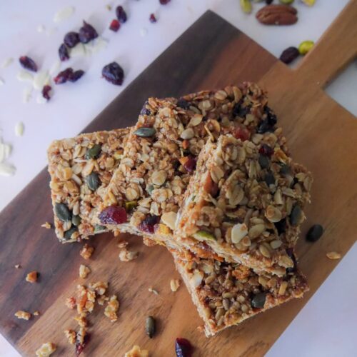 A wooden board topped with 5 slices of Christmas spiced flapjacks.