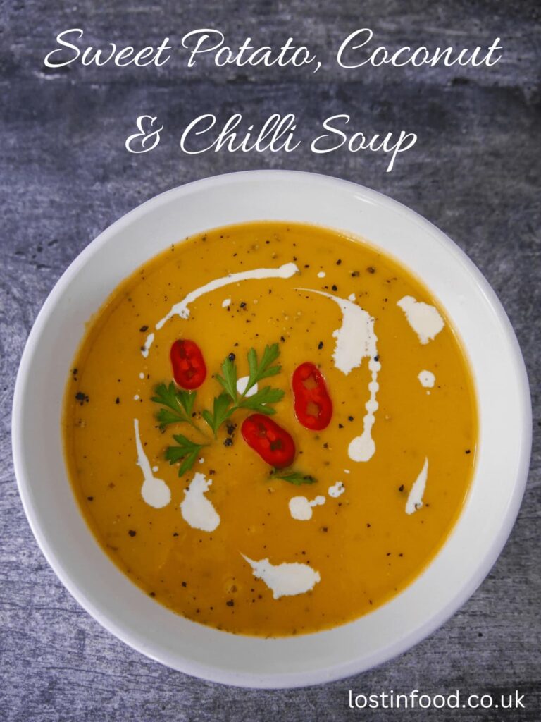 Pinnable image with recipe title and white bowl filled with sweet potato, coconut and chilli soup garnished with a drizzle of coconut milk, sliced red chillies and parsley.