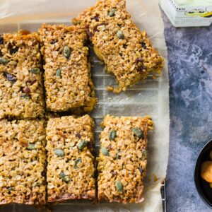 Almond apricot flapjacks cut up and set out on a sheet of baking parchment.