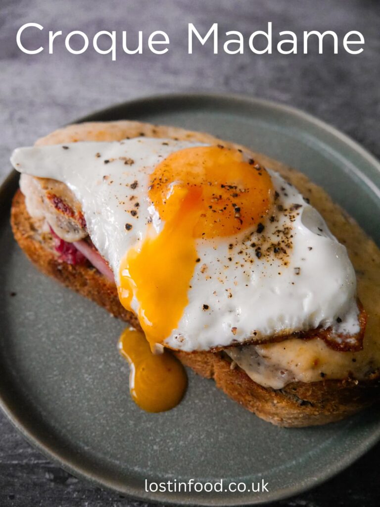 Pinnable image with recipe title and toasted croque madame toasted sandwich topped with a fried egg.