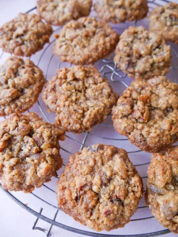 A wire cooling rack topped with date and oatmeal cookies.
