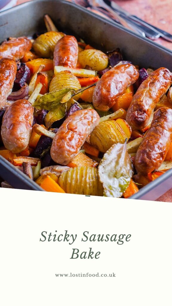 Pinnable image with recipe title and a large oven proof dish filled with roasted vegetables, hassleback potatoes and cooked sausages.