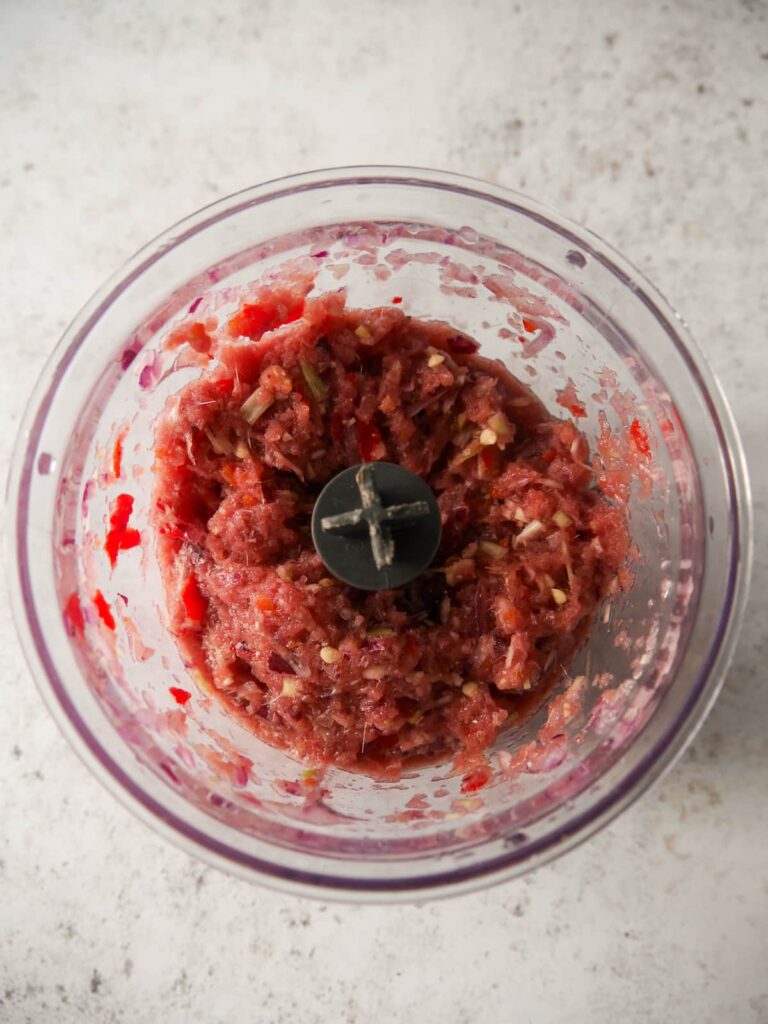 Small food processor filled with blitzed up beef rendang paste ingredients.