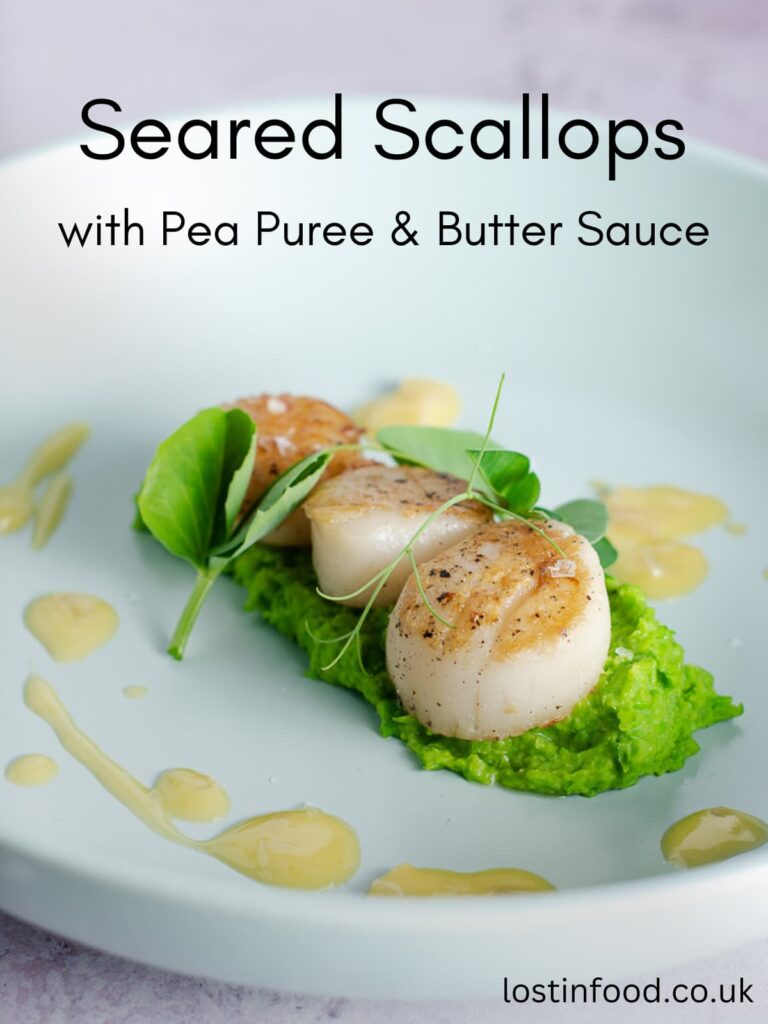 Pinnable image with recipe title and a blue bowl with pea puree, topped with three seared scallops with a drizzle of butter sauce and garnished with fresh pea shoots.