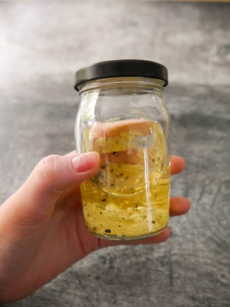 French dressing ingredients layered up in a glass jar.