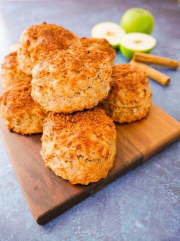 A batch of apple and cinnamon scones set on a wooden board.