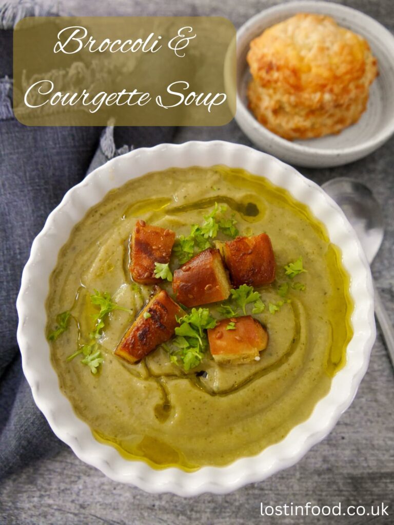 Pinnable image with recipe title and a bowl of broccoli and courgette soup topped with fresh parsley and croutons, with a cheese scone served alongside.