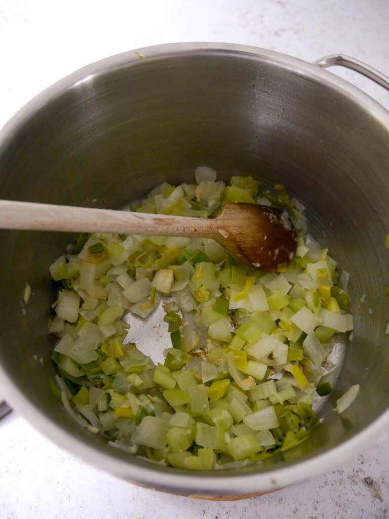 A saucepan with sauteed leek, onion and garlic.