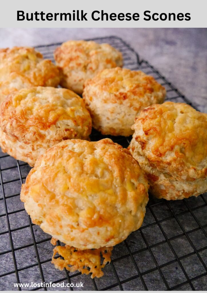 Pinnable image with recipe title and cheese scones resting on a wire cooling rack.