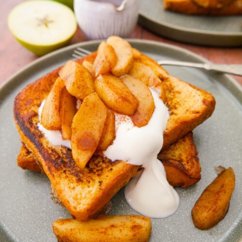 A plate topped with cinnamon French toast with a serving of cinnamon apples and Greek yogurt on top.