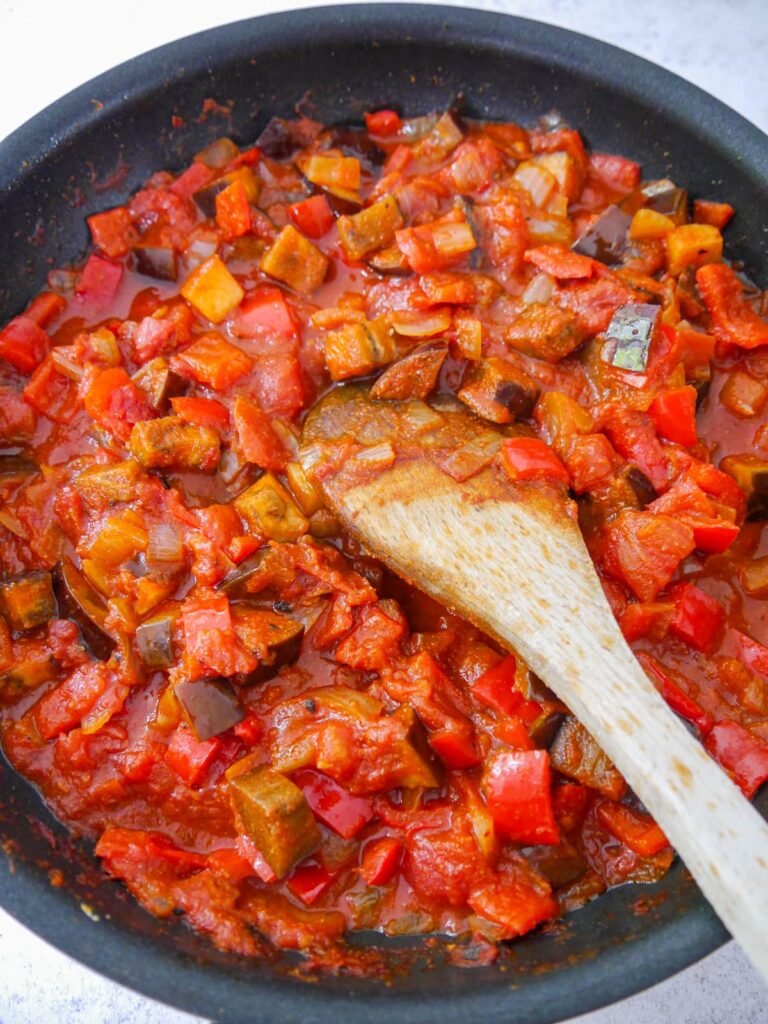 A frying pan filled with shakshuka cooked vegetable base ingredients.