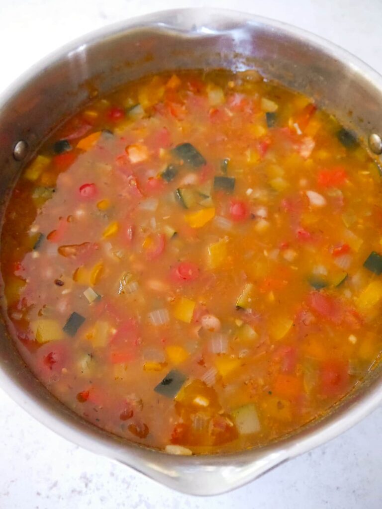 A large saucepan filled with spicy bean soup.