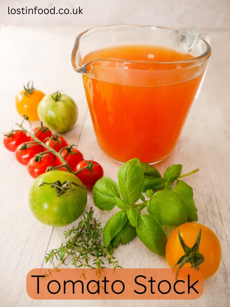 Pinnable image with recipe title and a glass jug filled with fresh tomato stock, with fresh tomatoes, basil and thyme leaves set alongside.