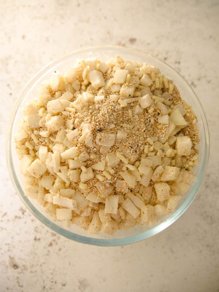 A glass bowl of mixed up oatmeal stuffing ingredients.