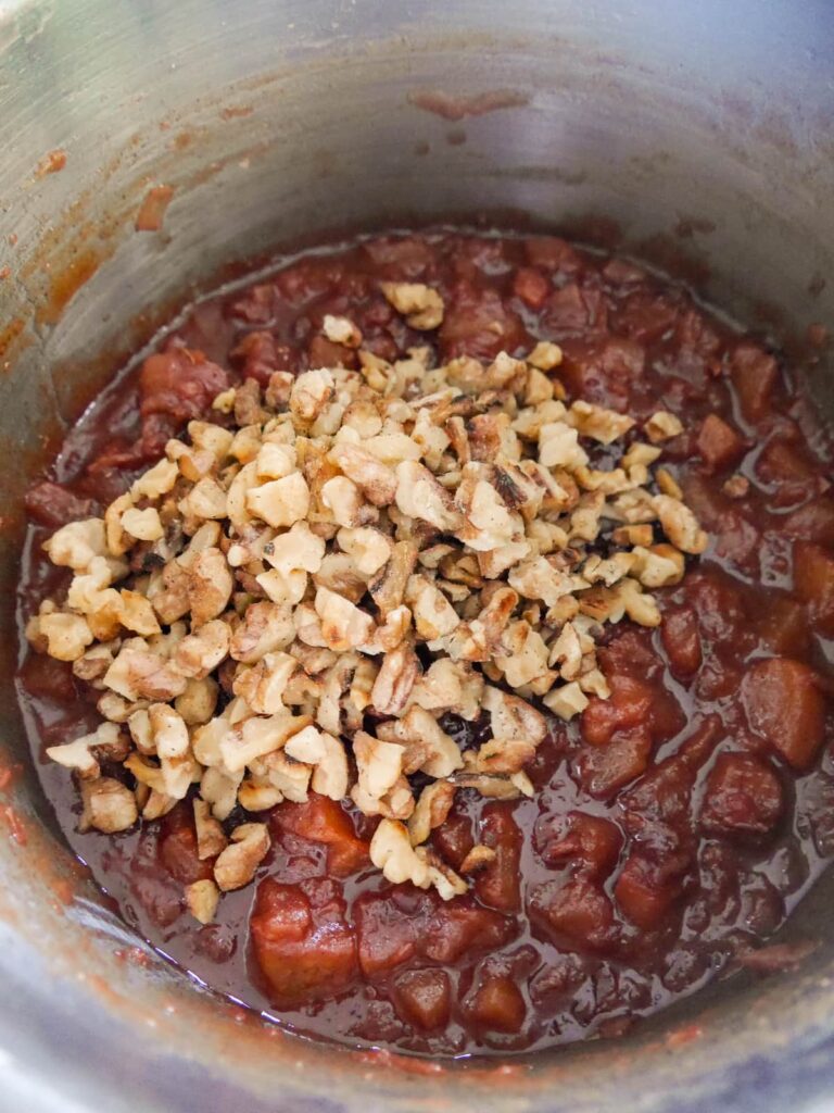 A saucepan of pear chutney with added roasted walnuts.