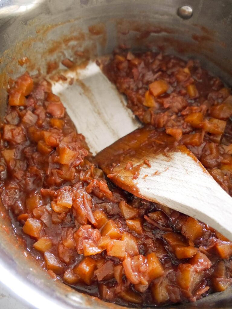 A saucepan of pear chutney with a wooden spatula.