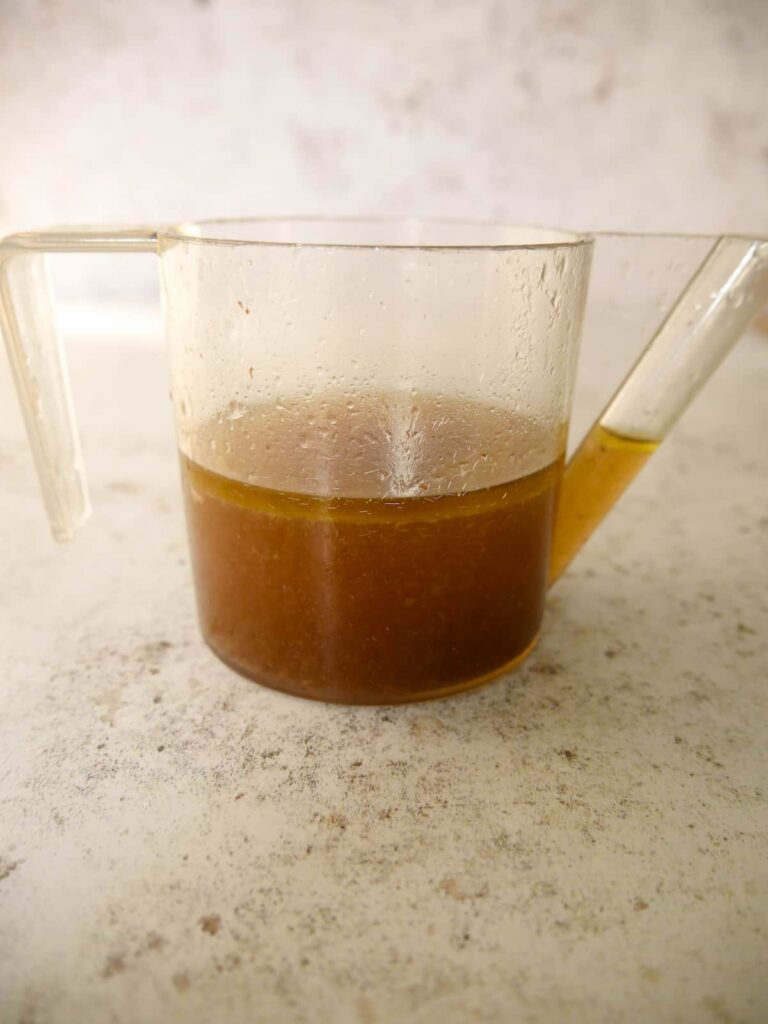 A fat separating jug filled with turkey cooking juices.