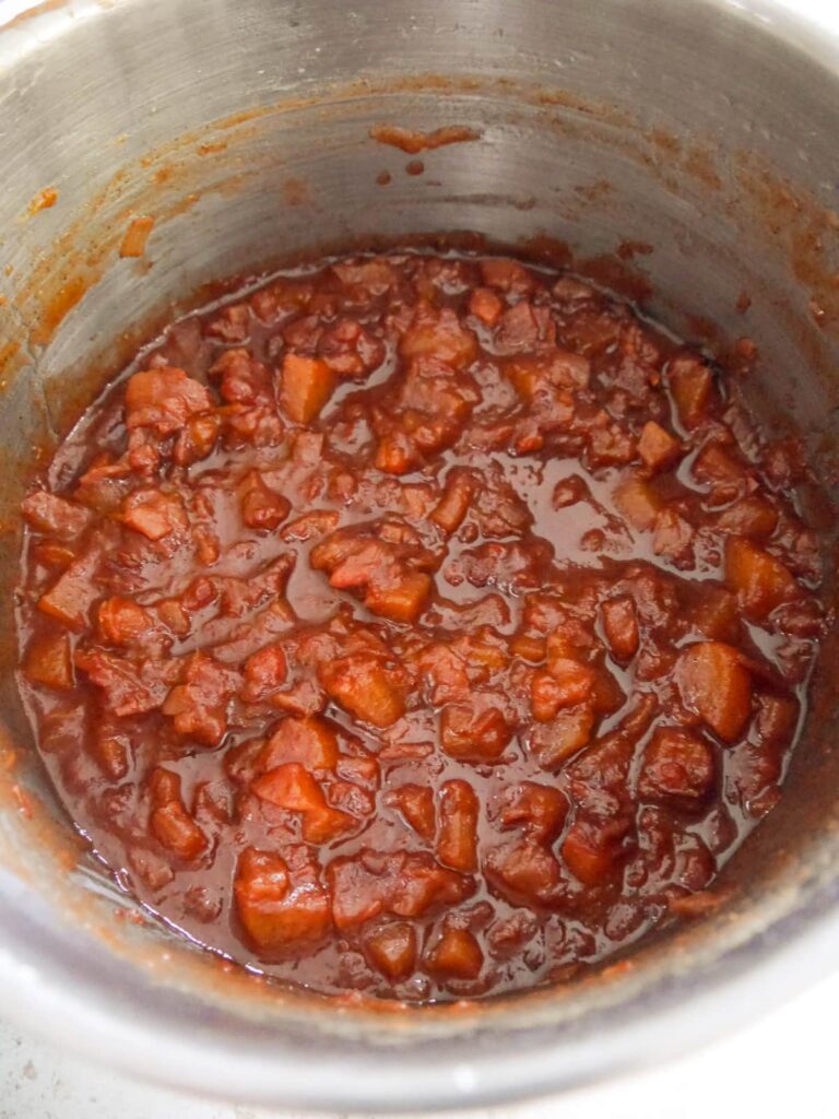 A saucepan of cooked pear and apple chutney.