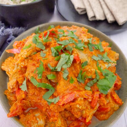 A bowl of leftover turkey curry, serve with sides of chapati flat breads and a bowl of steamed white rice.