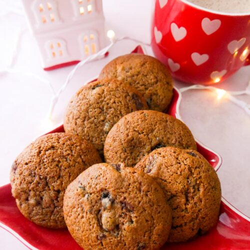 A plate topped with mincemeat cookies with a mug of hot chocolate set alongside.