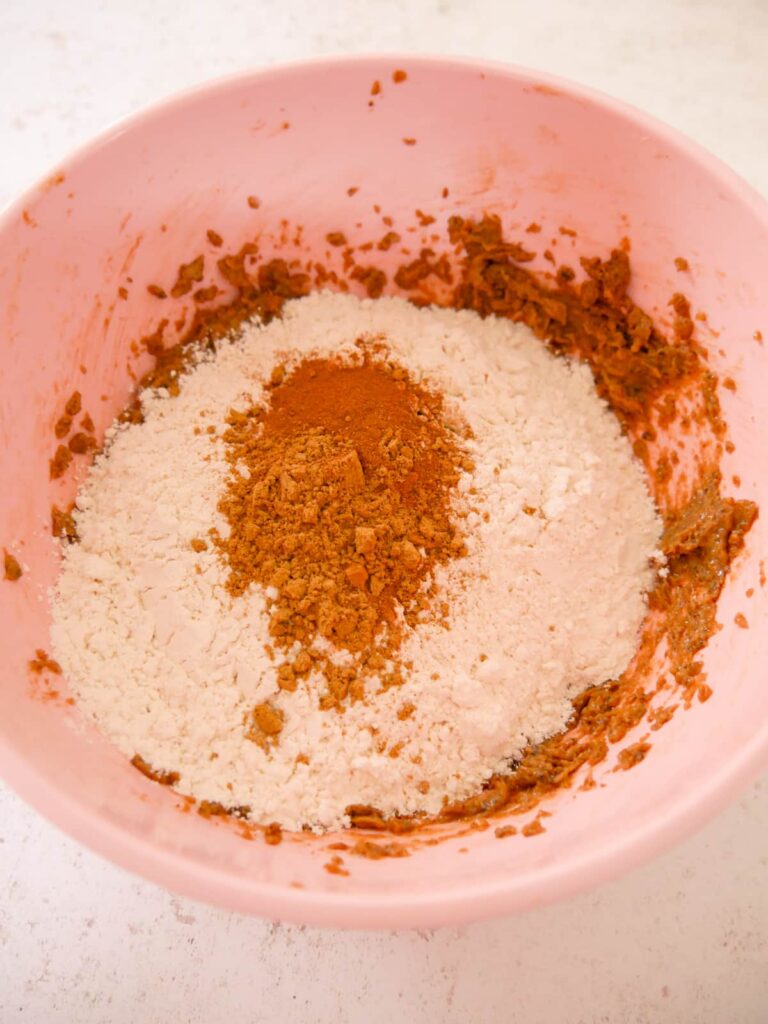 A bowl of creamed butter and sugar with added flour and ground spices.