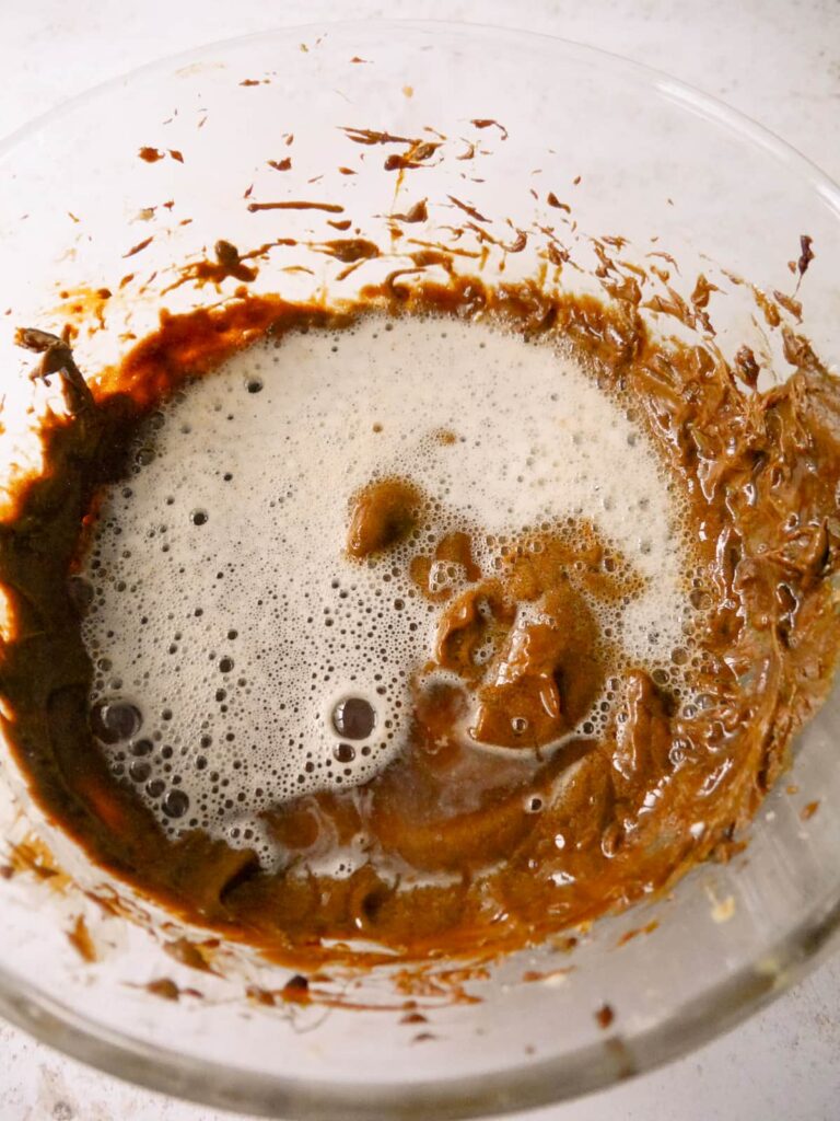 A bowl of combined sugar and butter with added bicarbonate of soda and water.