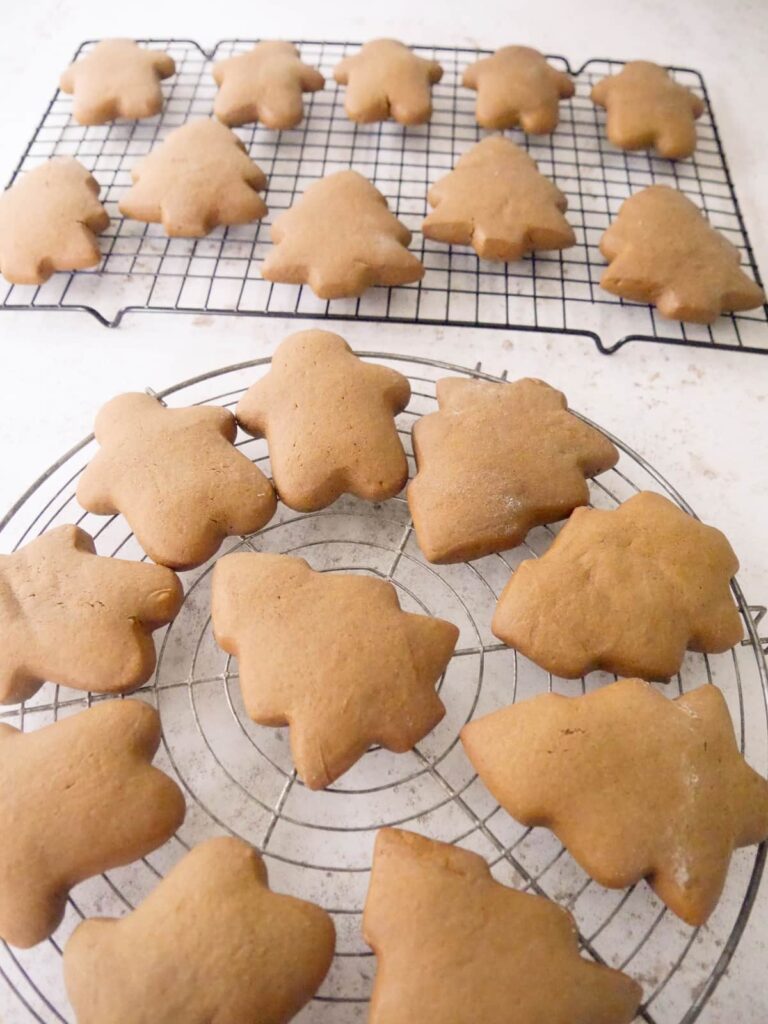 Christmas spiced cookies set on wire racks to cool.