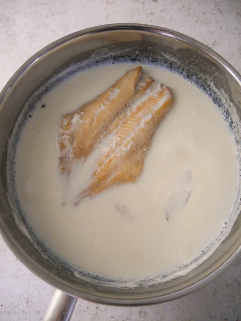 A pan with a smoked haddock fillet poaching in milk.