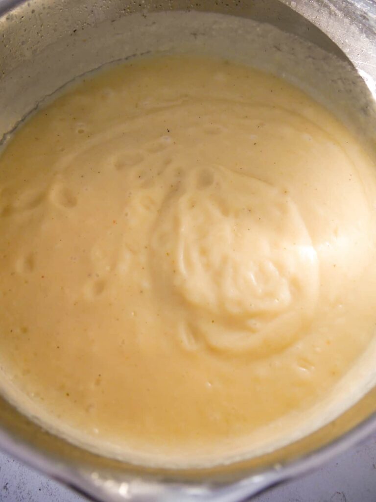 A saucepan of cooked and pureed parsnip soup.