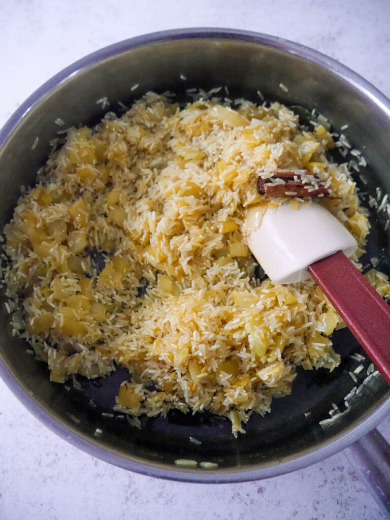 A frying pan fillet with sautéed onion and added whole spices and rice.