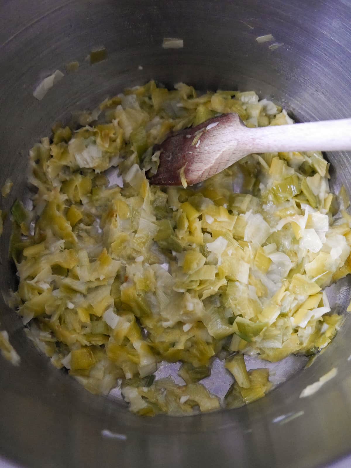 A saucepan with sauteed leek and garlic.