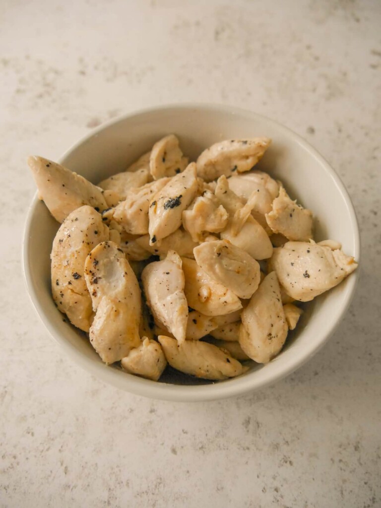 A bowl of stir-fried chicken pieces.