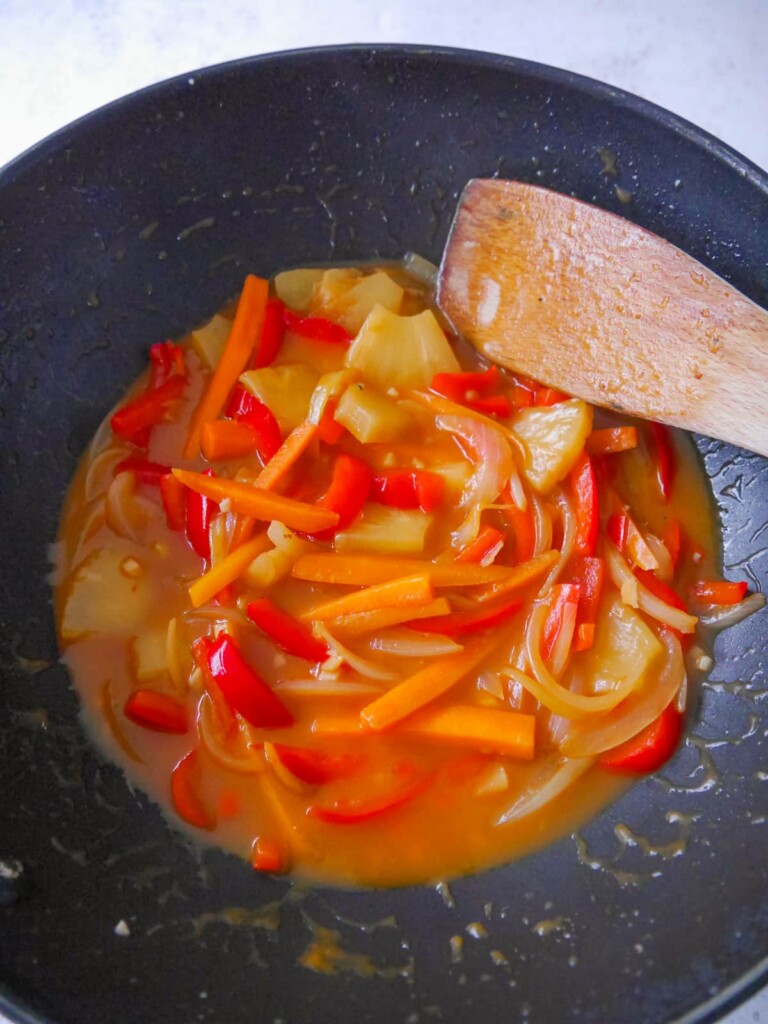 A wok filled with sweet and sour stir-fried vegetables.