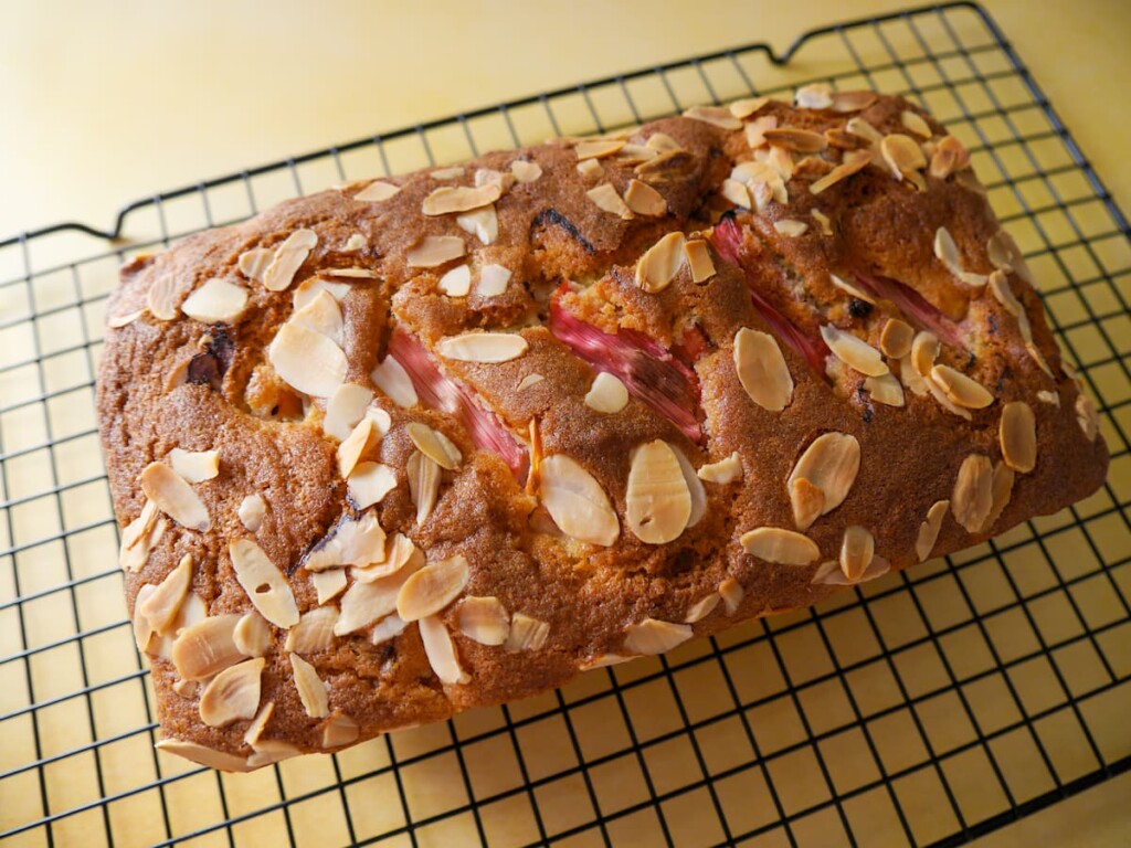 Rhubarb and almond loaf cake set on a wire cooling rack.