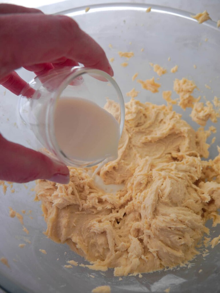 Large bowl of cake batter with added milk.