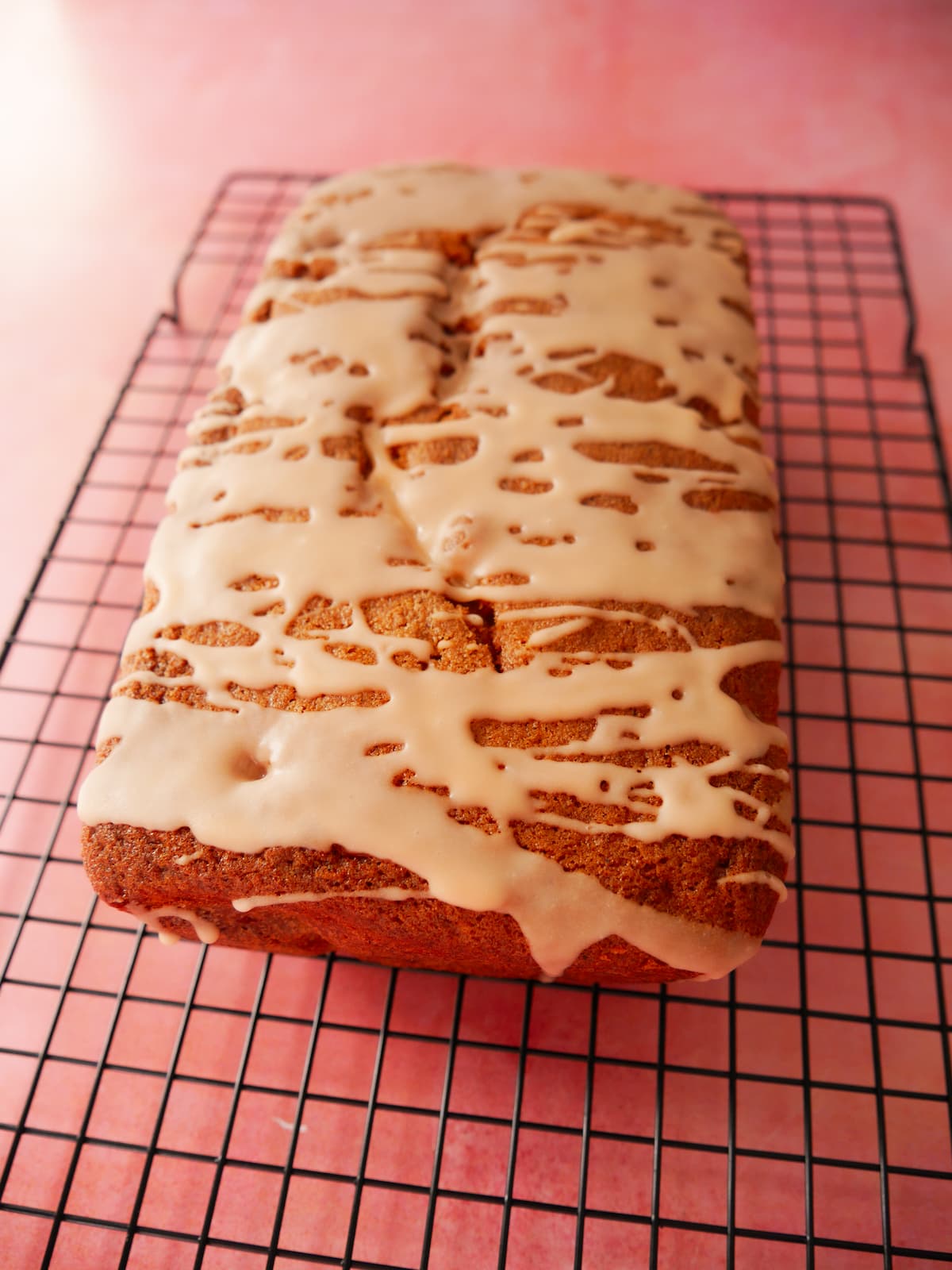 Rhubarb and orange loaf cake set on a wire cooling rack.