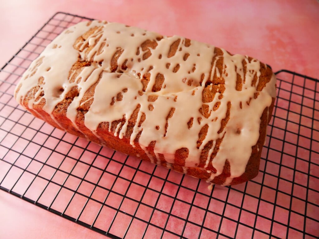 Rhubarb and orange loaf cake set on a wire cooling rack.