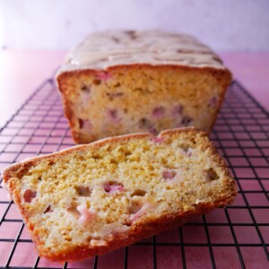 Rhubarb and orange loaf cake set on a wire cooling rack.