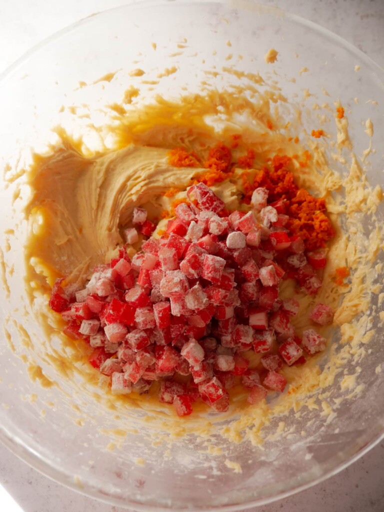 A bowl of cake batter with added orange zest and diced rhubarb.