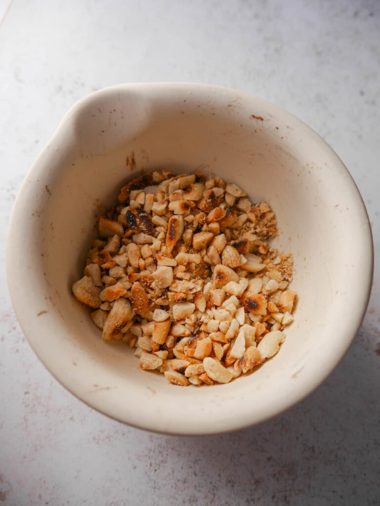 Pestle and mortar with crushed roasted peanuts.