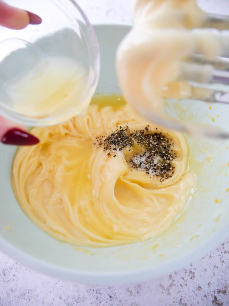 A bowl of whipped mayonnaise with added lemon juice, sea salt and black pepper.