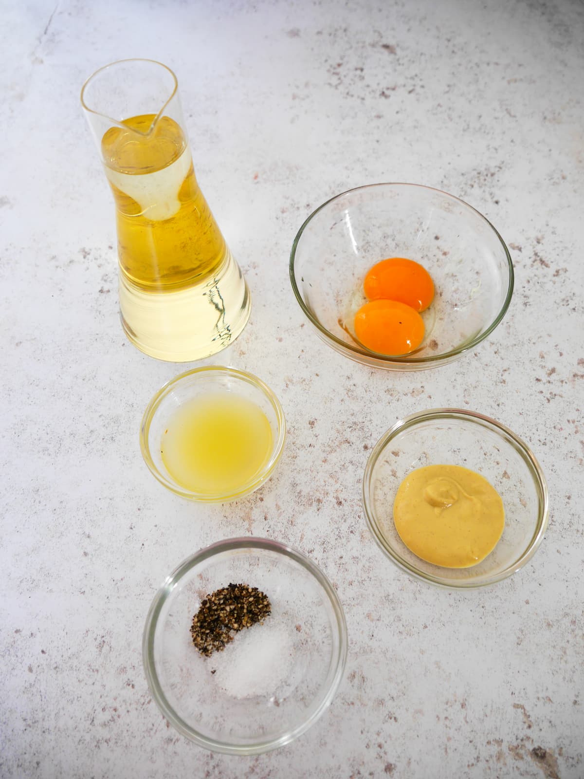 Individual recipe ingredients for making homemade mayonnaise.