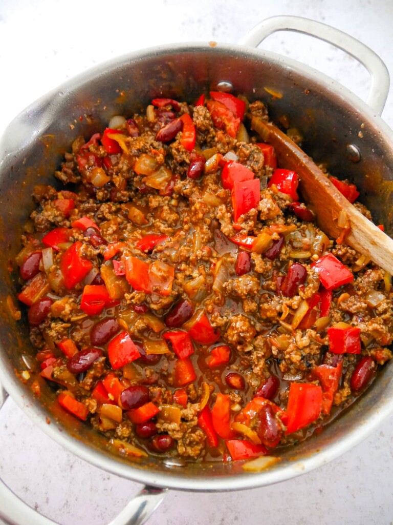 A large saucepan of the combined ingredients for minced beef chilli.