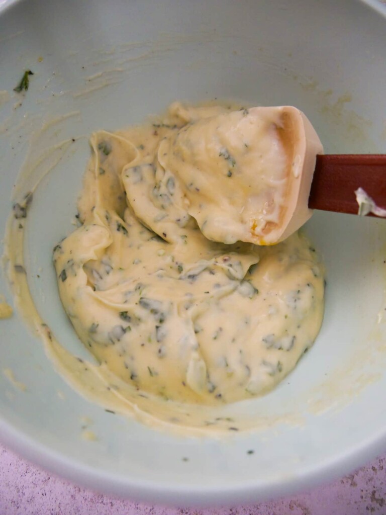 A bowl of homemade mayonnaise with added freshly chopped tarragon.