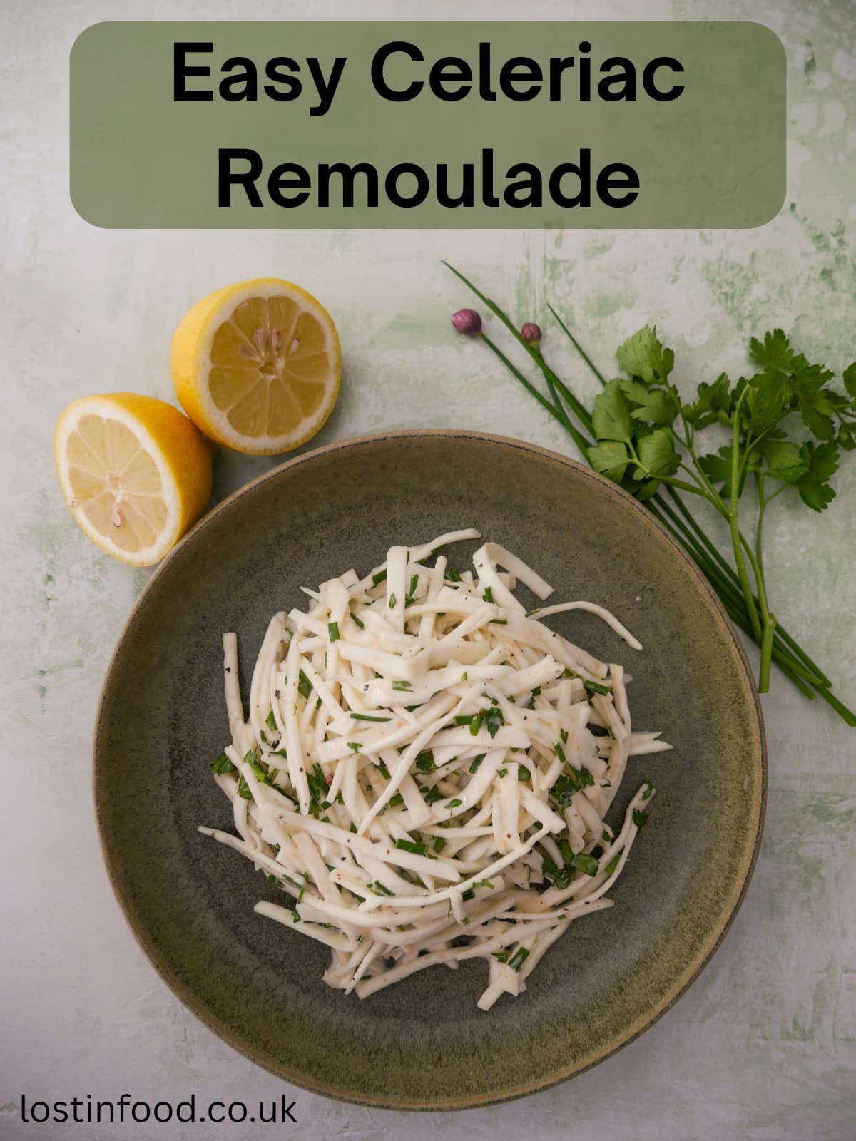 Pinnable image with recipe title and a green bowl of celeriac remoulade salad, with lemon and fresh parsley and chives set alongside.