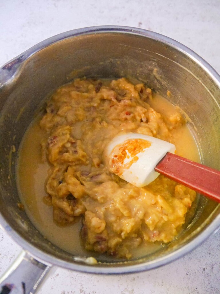 A saucepan with a thick flour roux base and added chicken stock.