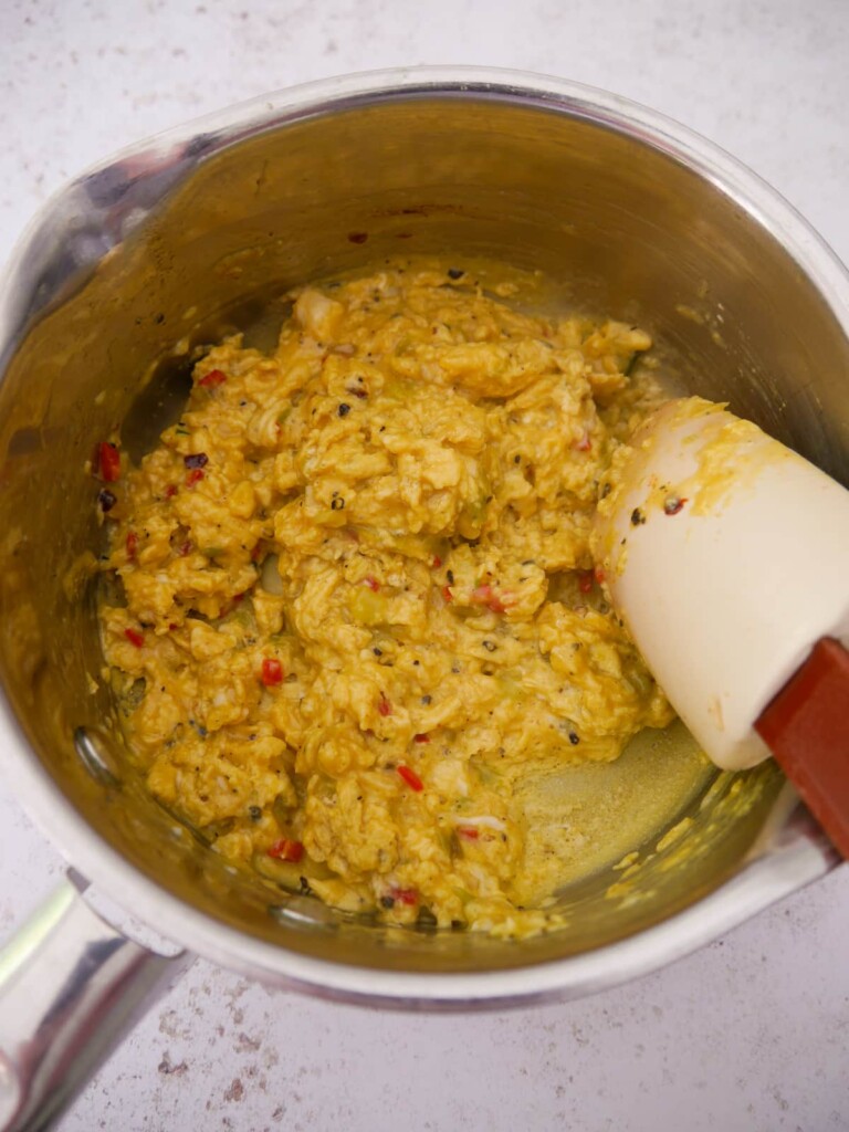 A saucepan of cooked curried scrambled eggs.