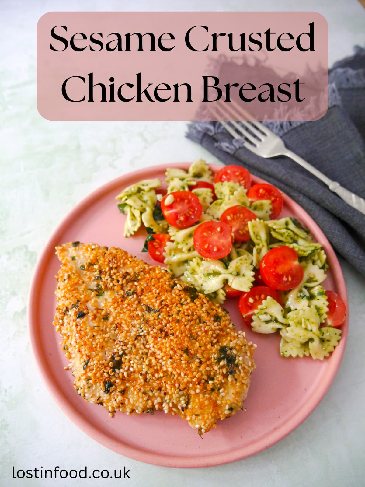 Pinnable image with recipe title and a pink plate topped with sesame crusted chicken breast with a side of pesto pasta salad and sliced cherry tomatoes.
