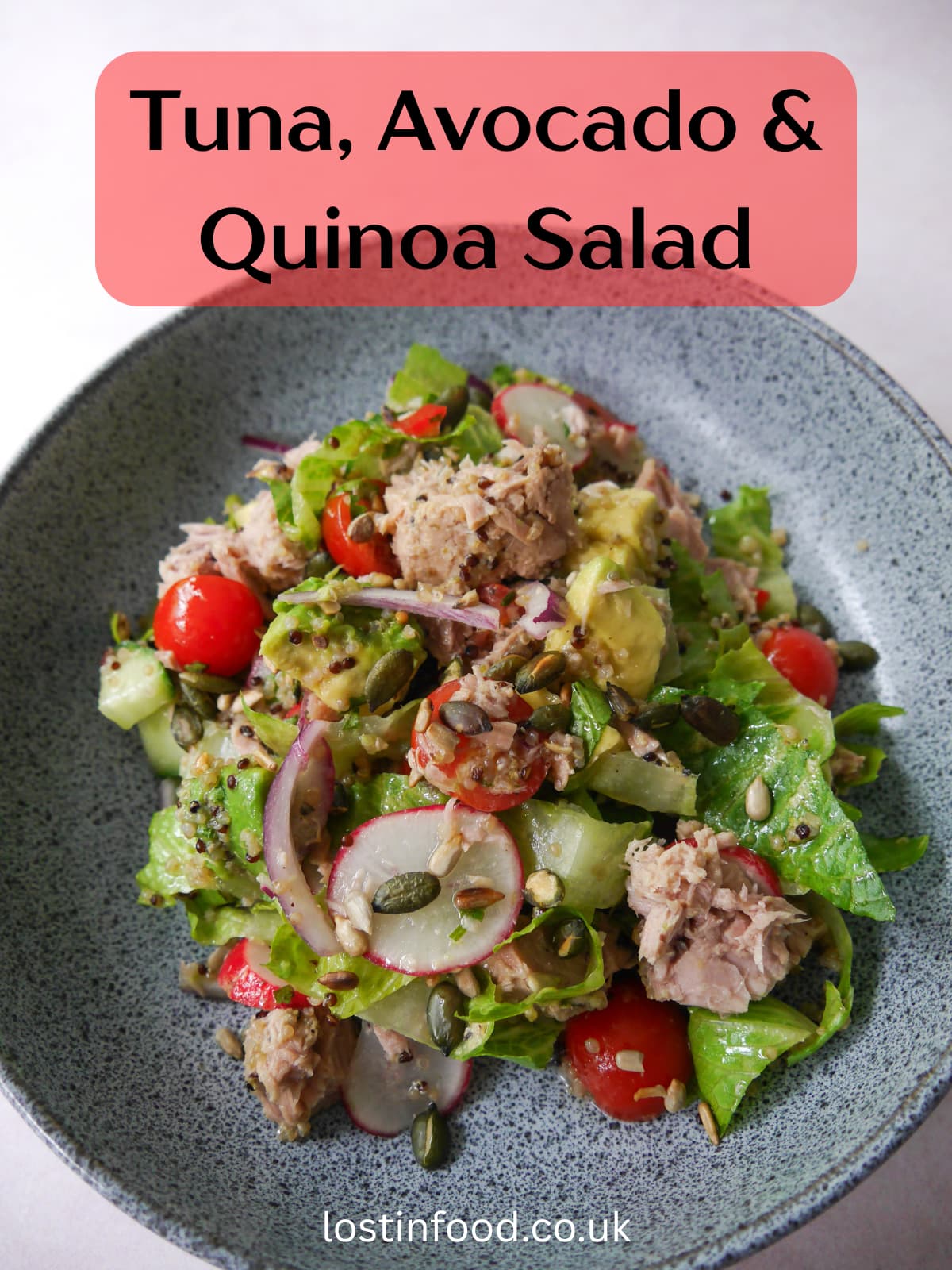 Pinnable image with recipe title and a bowl of tuna, avocado and quinoa salad, with crunchy salad vegetables and garnished with toasted seeds.